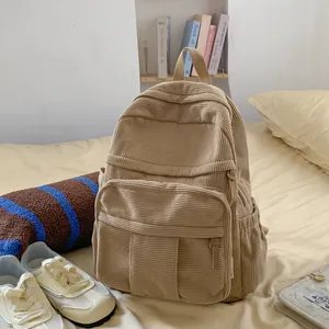 Detail eines khakifarbenen Cord-Rucksacks in einem gemütlichen Schlafzimmer-Ambiente