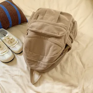 Detailansicht der beigefarbenen Cord-Rucksack-Struktur mit Fronttasche und Seitenfach