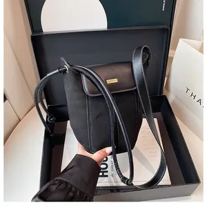 Detail of black bucket bag with white stitching and luxury gold metal buckle closure