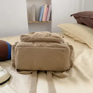 Detailierte Textur des beigen Cord-Rucksacks auf einem Bett mit vintage akademischer Optik