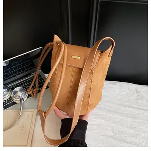 Detail of a brown bucket bag showing the mix of suede and smooth leather textures