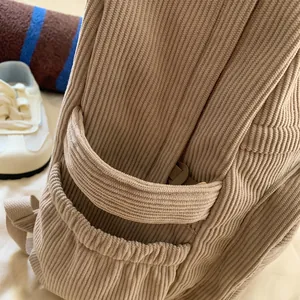 Detail der Kord-Rucksack-Seitentasche mit Gummizug und feiner gerippter Struktur