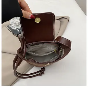 Detail view of the deep brown leather bag interior with zipper pocket and stitching