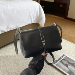 Elegante borsa a tracolla in pelle nera con fibbia in metallo dorato dallo stile retrò