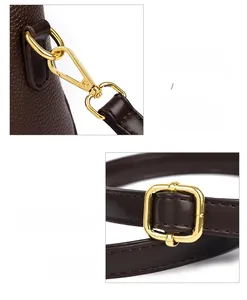 Detail of dark brown lychee leather texture and gold adjustable buckle on handbag strap
