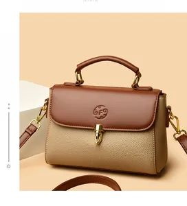 Close-up of the pebbled leather texture and gold lock on the brown satchel bag