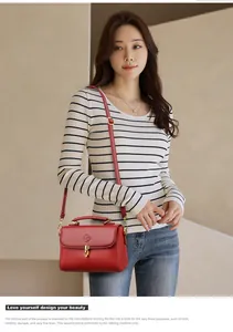 Detail of red leather tote bag showing lychee grain texture and gold metal latch