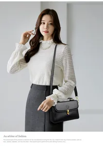 Close-up of black lychee grain leather handbag with gold metal twist lock and branding