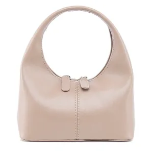 Detailansicht des Reißverschlusses und des geschwungenen Griffs einer beigen Ledertasche