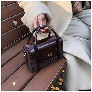 Detailed close-up of retro color-block handbag leather texture and golden metal logo