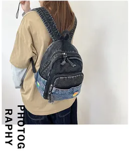 Gros plan du sac à dos en jean délavé avec patchwork rétro et logo arc-en-ciel