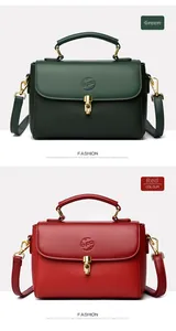 Close-up of luxury letter-embossed handbags in green and red with gold metal buckles