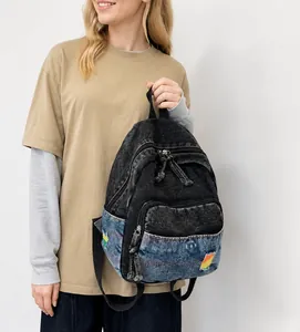 Détail du mini sac à dos en jean délavé avec écusson arc-en-ciel et design patchwork