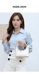 Modella che indossa una borsa a mano a mezzaluna bianca con eleganti dettagli di cucitura