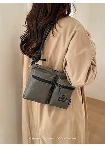 Detail view of water-resistant nylon tote bag with utility pockets and rope strap