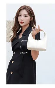 Detailansicht der weißen Hobo-Tasche aus Leder mit Metallverschluss und glatter Oberfläche