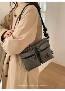 Detail of waterproof nylon crossbody bag with double front zippers and woven rope strap