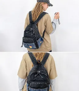 Détail du sac à dos en jean délavé gris avec broderie arc-en-ciel et poches zippées multiples