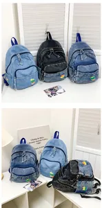Vue détaillée de mini sacs à dos en jean en trois couleurs avec patchs arc-en-ciel