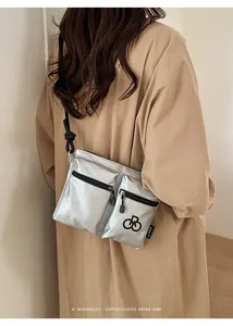 Detail of silver metallic nylon crossbody bag with multi-pockets and rope strap