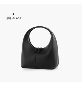 Detailansicht einer schwarzen minimalistischen Leder-Henkeltasche in trendiger Halbmondform