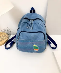 Détail de mini sac à dos en jean avec patch arc-en-ciel coloré et fermeture éclair durable