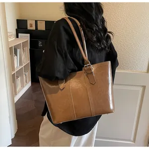 Détail du grand sac cabas marron avec coutures verticales et boucle en métal argenté