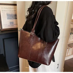 Détail du sac cabas vintage en cuir ciré marron foncé avec boucle et surpiqûres élégantes