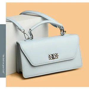 Detailed view of light blue baguette bag with silver twist lock and smooth leather texture