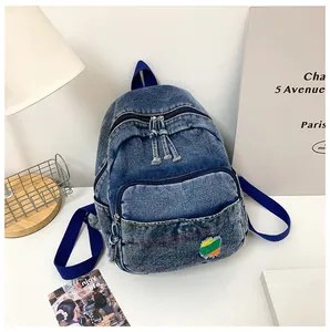 Gros plan détaillé sur la texture denim bleu délavé et le patch effiloché arc-en-ciel