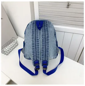 Vue détaillée du dos d'un sac à dos en jean avec bretelles en nylon et boucles