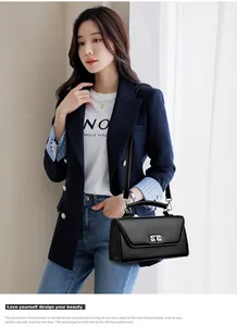 Close-up of a stylish black leather baguette bag with metal buckle and shoulder strap