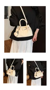 Detailed views of beige woven bucket bag with heart mirror charm and adjustable strap