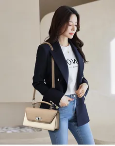Detail of khaki and off-white baguette bag with silver metal twist lock and shoulder strap