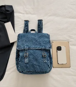 Detalle de mochila vaquera lavada con correas de hebilla metálica y textura retro
