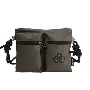Waterproof army green nylon crossbody bag with dual front pockets and thick rope strap