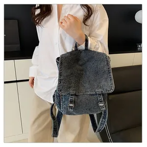 Detalle de mochila vintage de mezclilla lavada con correas de hebilla metálica doble