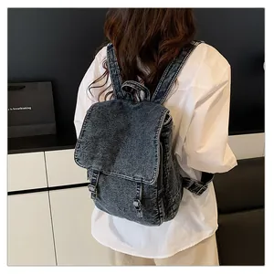 Detalle de la mochila de mezclilla lavada vintage con correas y acabados metálicos retro