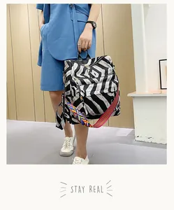 Detail of zebra pattern backpack with colorful woven straps and multiple zipper pockets