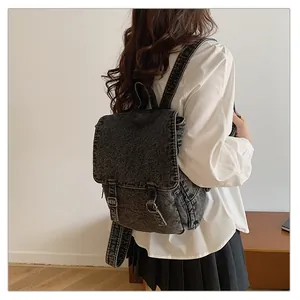 Vista lateral de mochila vaquera gris oscuro con hebillas metálicas en modelo