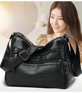 Detail view of the black washed leather shoulder bag with multi-pocket zippers and strap