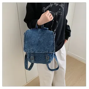 Detalle de la mochila de mezclilla lavada con hebillas metálicas y textura robusta