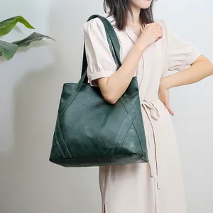 Detail of deep green washed soft leather tote bag featuring diagonal striped patchwork design