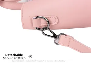 Detail van afneembare schouderriem met metalen haken op een roze emmer-tas van kunstleer