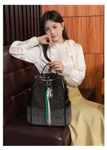 Détail d'un sac à dos noir avec dégradé de rivets argentés et pendentif ours
