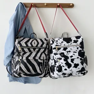 Cow and zebra print PU leather backpacks with vibrant red straps for travel