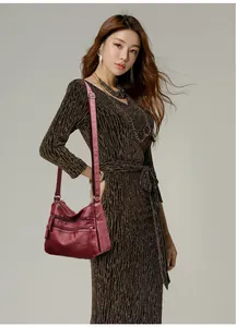 Detail view of burgundy soft leather shoulder bag with multiple functional zippers