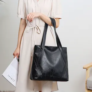 Detail of black washed PU leather tote bag with geometric stitching on soft material