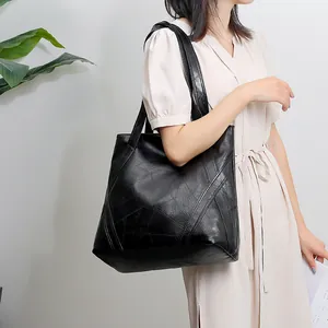 Detail shot of the black leather tote bag featuring stylish geometric stitching patterns
