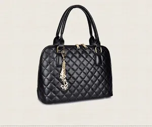 Detail view of the black quilted shell handbag with gold hardware and butterfly charm